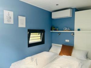 Habitación azul con cama y espejo en Hausboot CALIENE - LP9, en Höxter