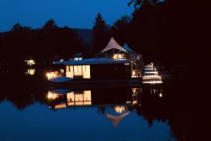 a small house on the water at night at Hausboot CALIENE - LP9 in Höxter