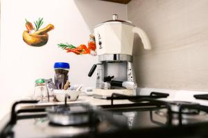 una macchinetta del caffè seduta sopra un bancone della cucina di Flower's House 24 - Central Apartment - Molfetta a Molfetta