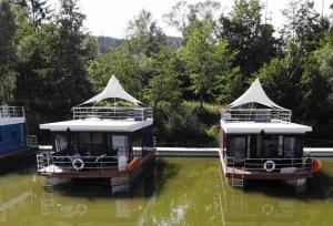 two boats are docked in the water at Hausboot Scarlett - LP5 in Höxter