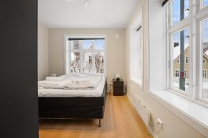 a bedroom with a bed in a room with windows at Homelike and Cozy Apt close to City Centre in Stavanger
