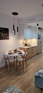 a kitchen and dining room with a table and chairs at Holiday Sunset Blvd Apartment for Two in Darłowo