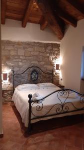 1 dormitorio con 1 cama grande en una pared de piedra en Agriturismo Ca' de' Magnani, en Baragazza