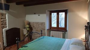 1 dormitorio con cama y ventana en Agriturismo Ca' de' Magnani, en Baragazza