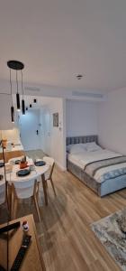 a bedroom with a bed and a table and a dining room at Holiday Sunset Blvd Apartment for Two in Darłowo