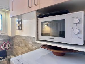 a microwave oven on a shelf in a kitchen at Maison du Centre - GestingHome in Sauze d'Oulx