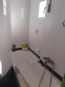 a bathroom with a bath tub with a shower at Suburbs Georgia's loft in country side 15' from the Airport in Paianía