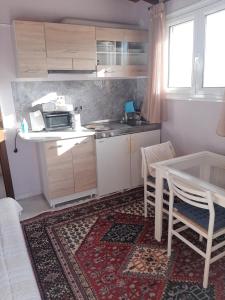 a small kitchen with a table and a table and chairs at Suburbs Georgia's loft in country side 15' from the Airport in Paianía