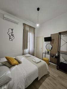 een slaapkamer met een groot bed en een televisie bij B&B GREEN Stazione Centrale in Reggio di Calabria