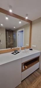 a bathroom with a sink and a large mirror at Holiday Sunset Blvd Apartment for Two in Darłowo