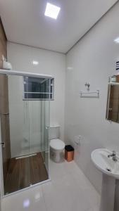 a bathroom with a shower and a toilet and a sink at Pousada Barbosa in Aparecida