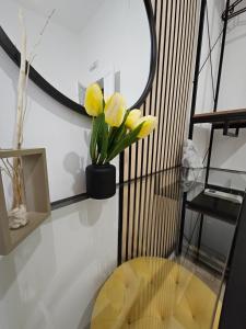 een kamer met een ronde glazen tafel en gele tulpen bij B&B GREEN Stazione Centrale in Reggio di Calabria