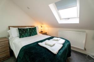 a bedroom with a bed with two towels on it at 3 Double BR | WiFi | Smart TV in Cardiff