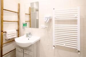 un bagno bianco con lavandino e doccia di Flower's House 24 - Central Apartment - Molfetta a Molfetta