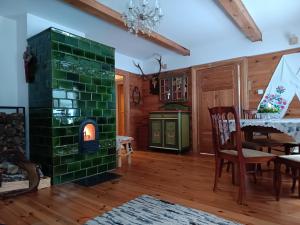 a living room with a green brick fireplace at Dębowe Królestwo Leśniczówka w Puszczy na wyłączność in Policzna