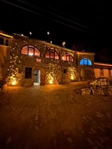 um edifício de pedra com luzes acesas à noite em Asma Altı Cave Suit's em Nar