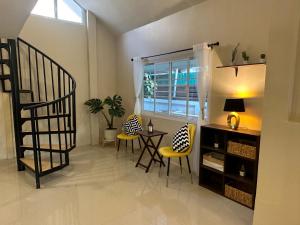 ein Wohnzimmer mit einer Treppe, einem Tisch und Stühlen in der Unterkunft Luxury Thai Escape in Chiang Mai
