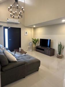 a living room with a couch and a flat screen tv at Luxury Thai Escape in Chiang Mai