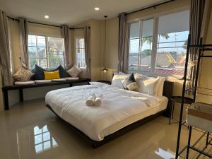 Un dormitorio con una cama grande con dos zapatos. en Luxury Thai Escape, en Chiang Mai