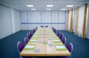 a large conference room with a long table and purple chairs at Hotel Bessunger Forst in Roßdorf