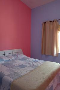 a bedroom with a bed and a window at Chalé casa di Taipa in Lagoa Nova