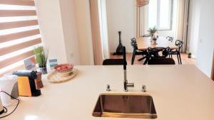 a kitchen counter with a sink and a table at SurfSoul Guesthouse - Bed and Breakfast in Peniche