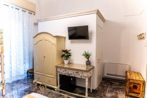 ein Wohnzimmer mit einem Kamin und einem TV an der Wand in der Unterkunft Palazzo dei Don in Racale