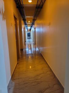 un lungo corridoio con pareti gialle e pavimento in legno di Hotel Deepak Retreat a Gudivāda