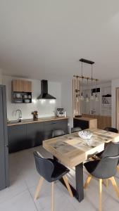 eine Küche mit einem Holztisch und Stühlen in der Unterkunft Spacieux appartement au pied des pistes in La Feclaz