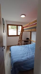 - une chambre avec des lits superposés et une échelle dans l'établissement Spacieux appartement au pied des pistes, à La Féclaz
