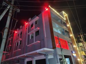 un edificio con luci rosse sul lato di Hotel Deepak Retreat a Gudivāda