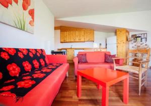 sala de estar con sofá rojo y mesa en Cal Martí, en Montsonís