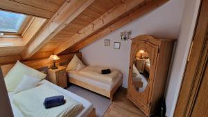 a attic room with two beds and a mirror at Hotel Ferienhaus Fux in Oberammergau