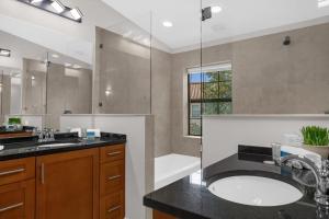 a bathroom with a sink and a tub and a mirror at Huge 4BR Townhouse 1 Mile to Disney - Perfect for Big Families in Orlando