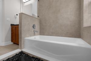uma casa de banho com uma banheira branca e um lavatório. em Huge 4BR Townhouse 1 Mile to Disney - Perfect for Big Families em Orlando