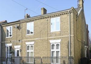 a brick building with white windows and a fence at Alma Rise in Melton