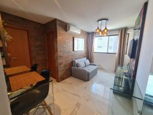 un soggiorno con tavolo e divano di Apartamento em boa viagem a Recife