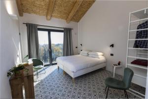 a bedroom with a bed and a chair and a window at Cascina Rüral in Montafia