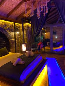 a bedroom with a large bed with purple lighting at Zamane evleri in Çamlıhemşin