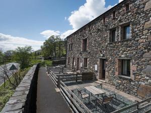 a group of benches sitting outside of a stone building at 3 Bed in Threlkeld SZ083 in Threlkeld