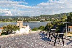 balcón con sillas y vistas al agua en Casa de Campo con vista al lago! Villa del Lago - Villa Carlos Paz en Villa Carlos Paz