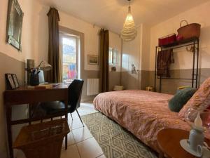 a bedroom with a bed and a desk and a desk at Invitation au voyage sur cour in Sète