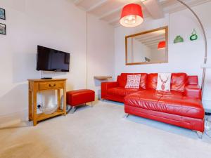 a living room with a red couch and a tv at 1 Bed in Cleobury Mortimer 82957 in Cleobury Mortimer