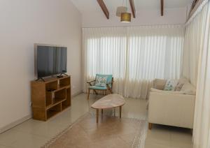 a living room with a tv and a couch at Villa Serenidad Costera in Sardinal