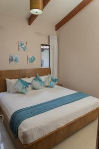 a bedroom with a large bed with blue pillows at Villa Serenidad Costera in Sardinal