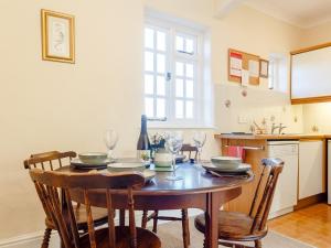 een keuken met een houten tafel met stoelen en een tafel bij 2 Bed in Holsworthy 77555 in Black Torrington