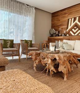 a living room with a table made out of a tree stump at Luxury Palms Puerto Arista in Puerto Arista