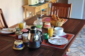 una mesa de madera con alimentos para el desayuno y bebidas. en La Petite Tuilerie en Villefranche-Sur-Cher