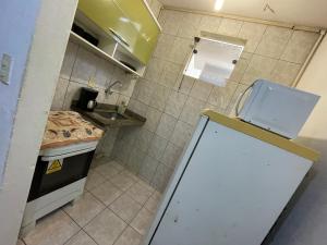 a small kitchen with a sink and a refrigerator at Apto Antonio Centro in Campos dos Goytacazes