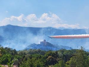 an airplane flying over a forest with a mountain at B&B Relais Cascina al Campaccio in Taino